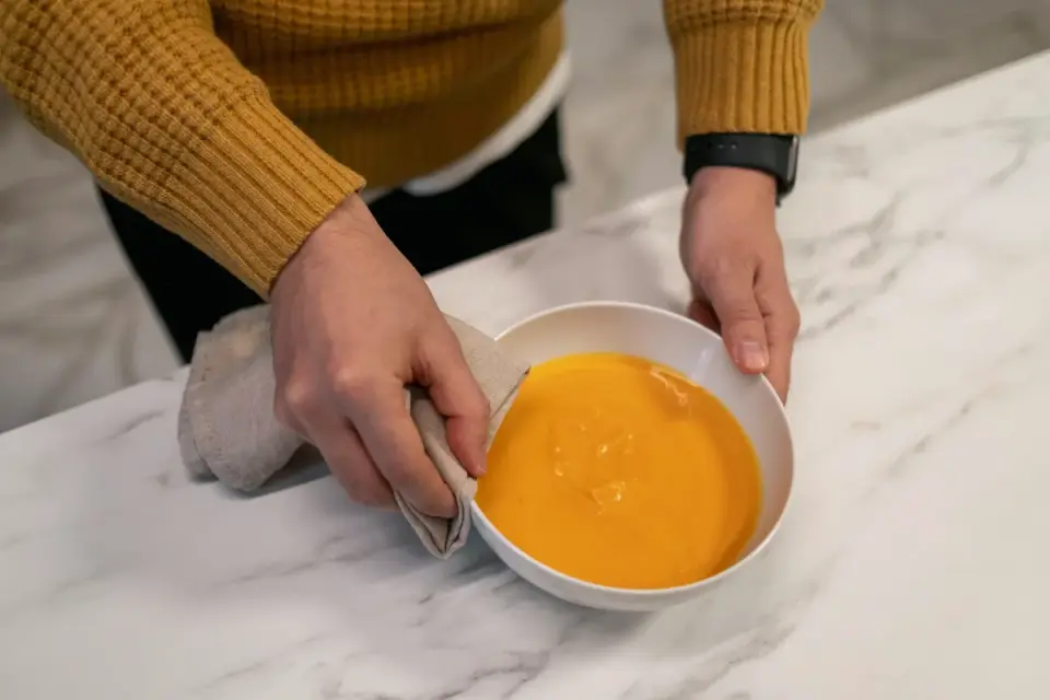 A dog eating a meal with pumpkin puree mixed into the kibble