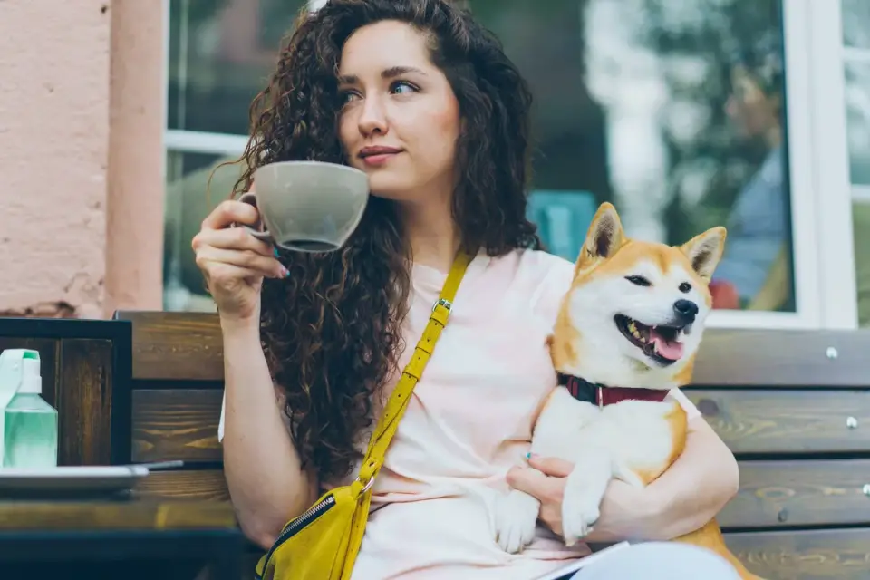 A dog owner reading the ingredient panel on a pet supplement bottle