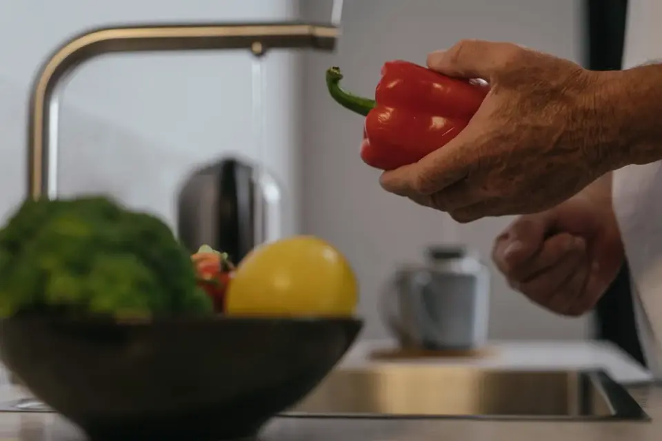 A senior dog eating from a bowl in a home kitchen