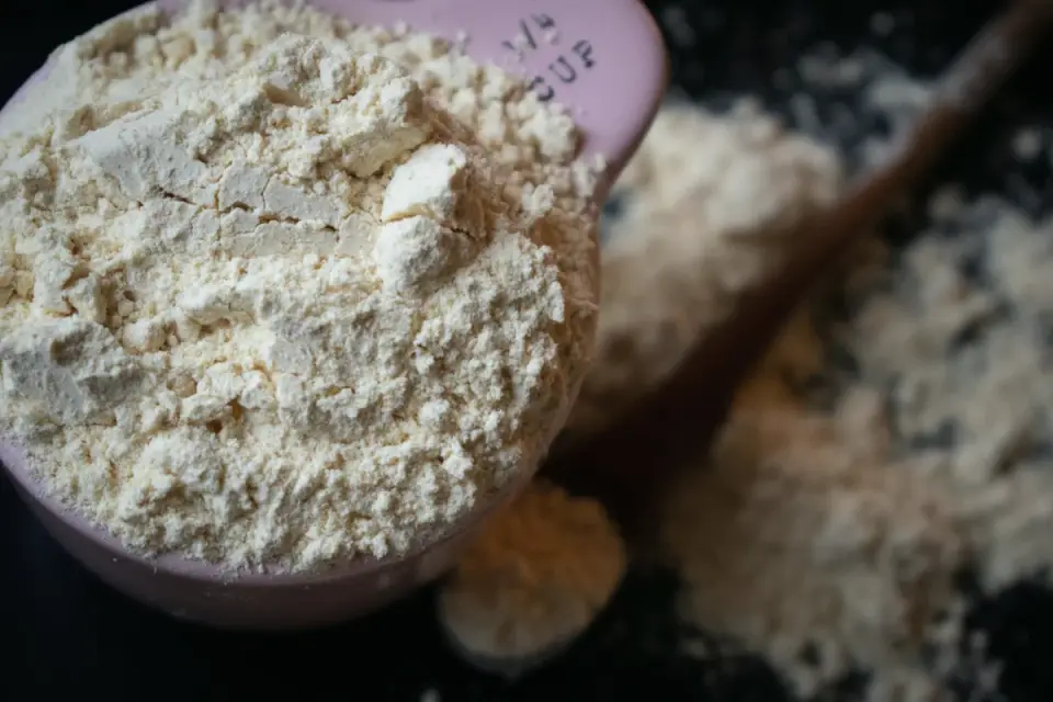 A small measuring spoon holding orange pumpkin powder