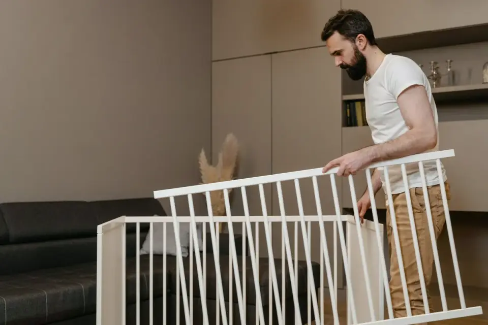 A small playpen set up in a living room with a dog bed inside