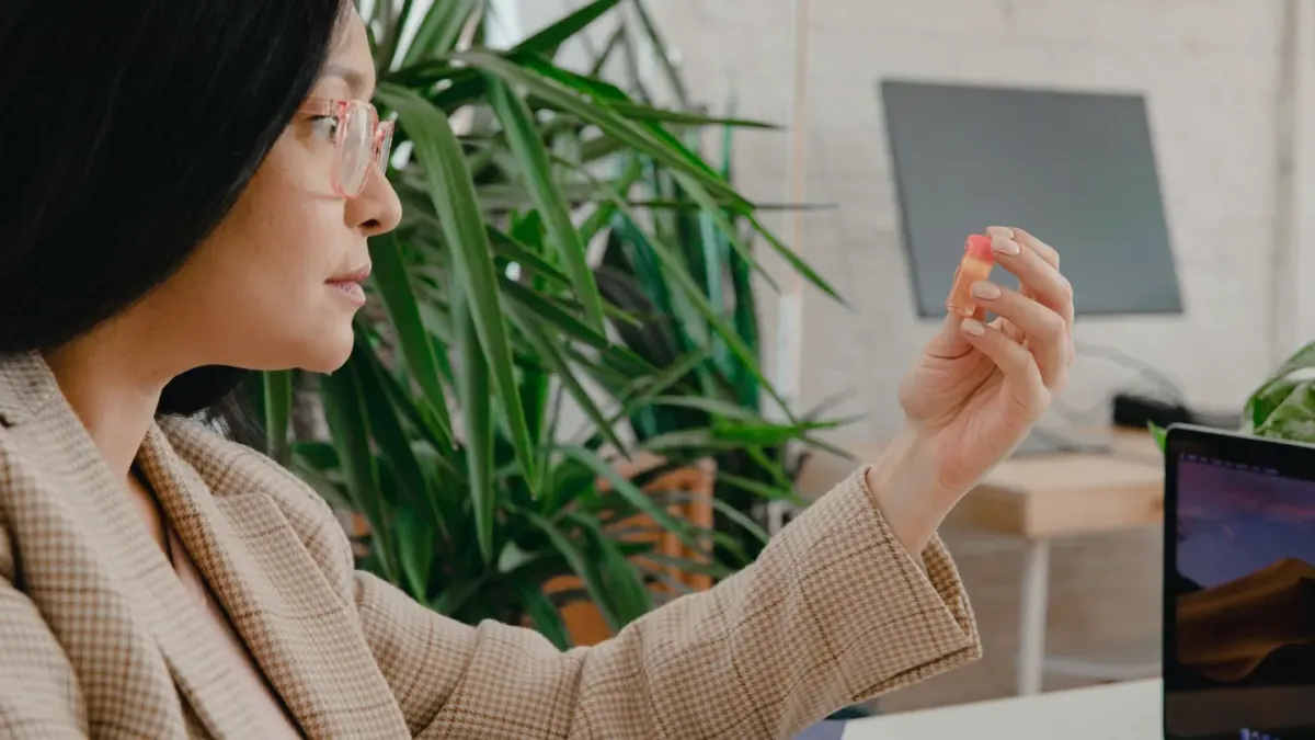 A veterinarian turning over a dog supplement bottle to read the ingredient panel