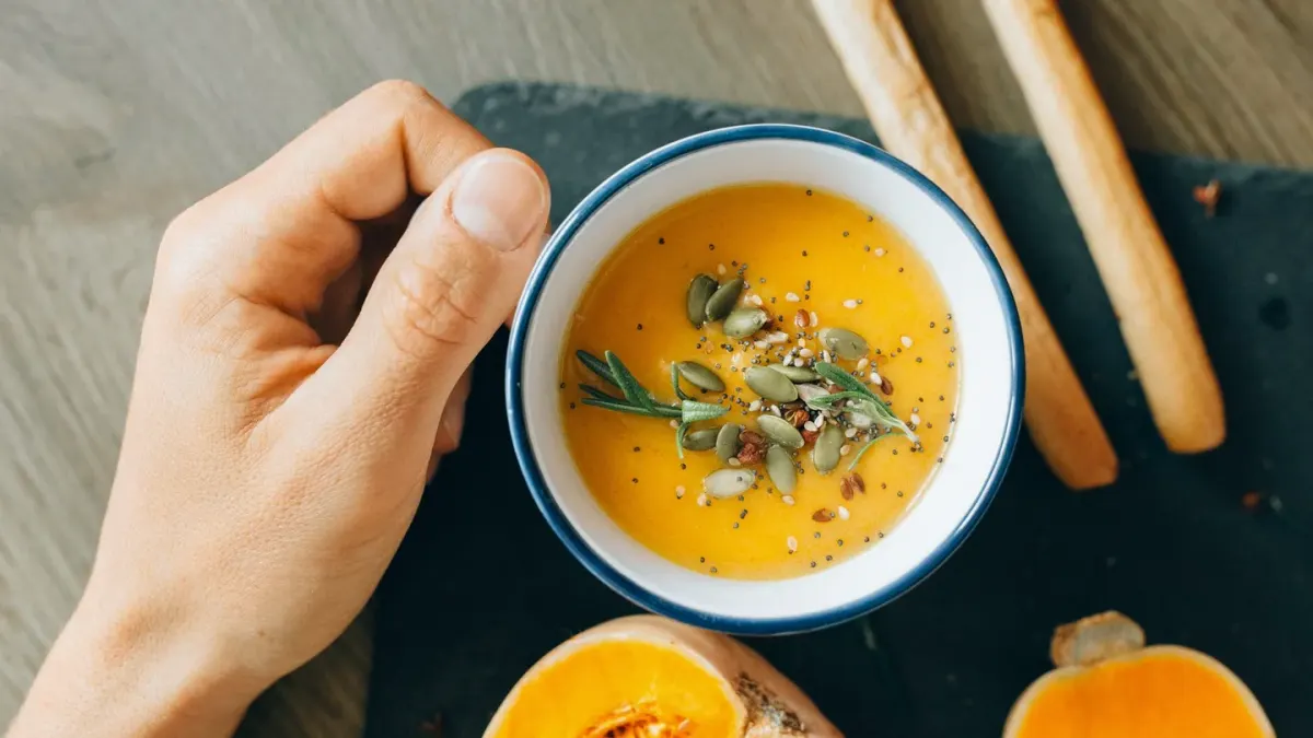 An open can of pumpkin puree beside a small bowl of pumpkin powder on a kitchen counter