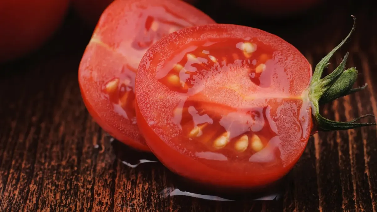 Sliced ripe red tomatoes on a cutting board with a dog nearby