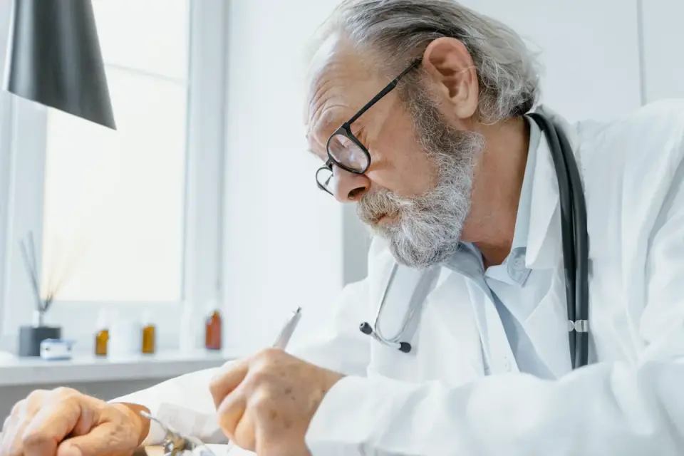 Veterinarian palpating an older dog&#x27;s front leg joint during an exam